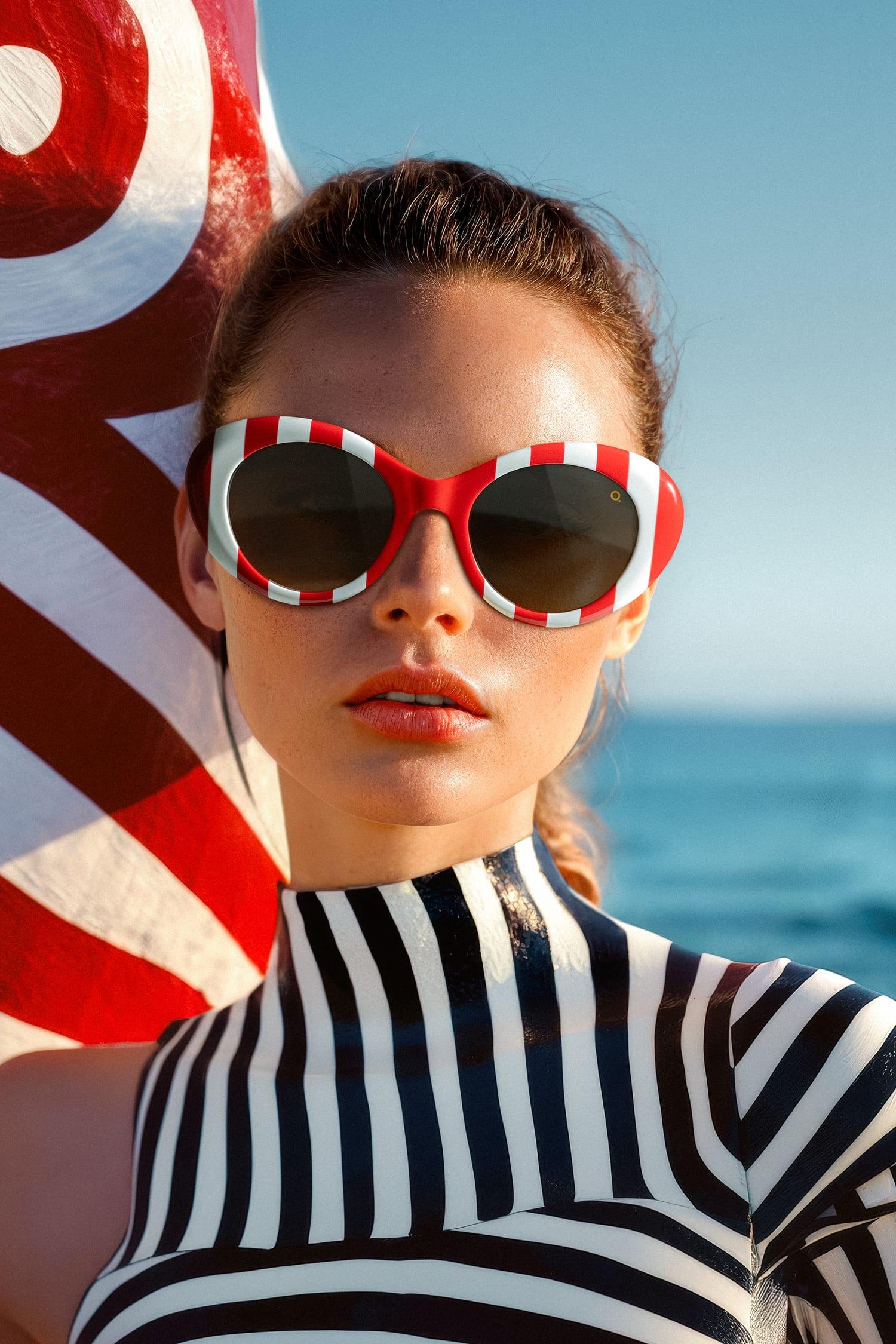 Model met rood-witte Etnia Barcelona zonnebril op het strand