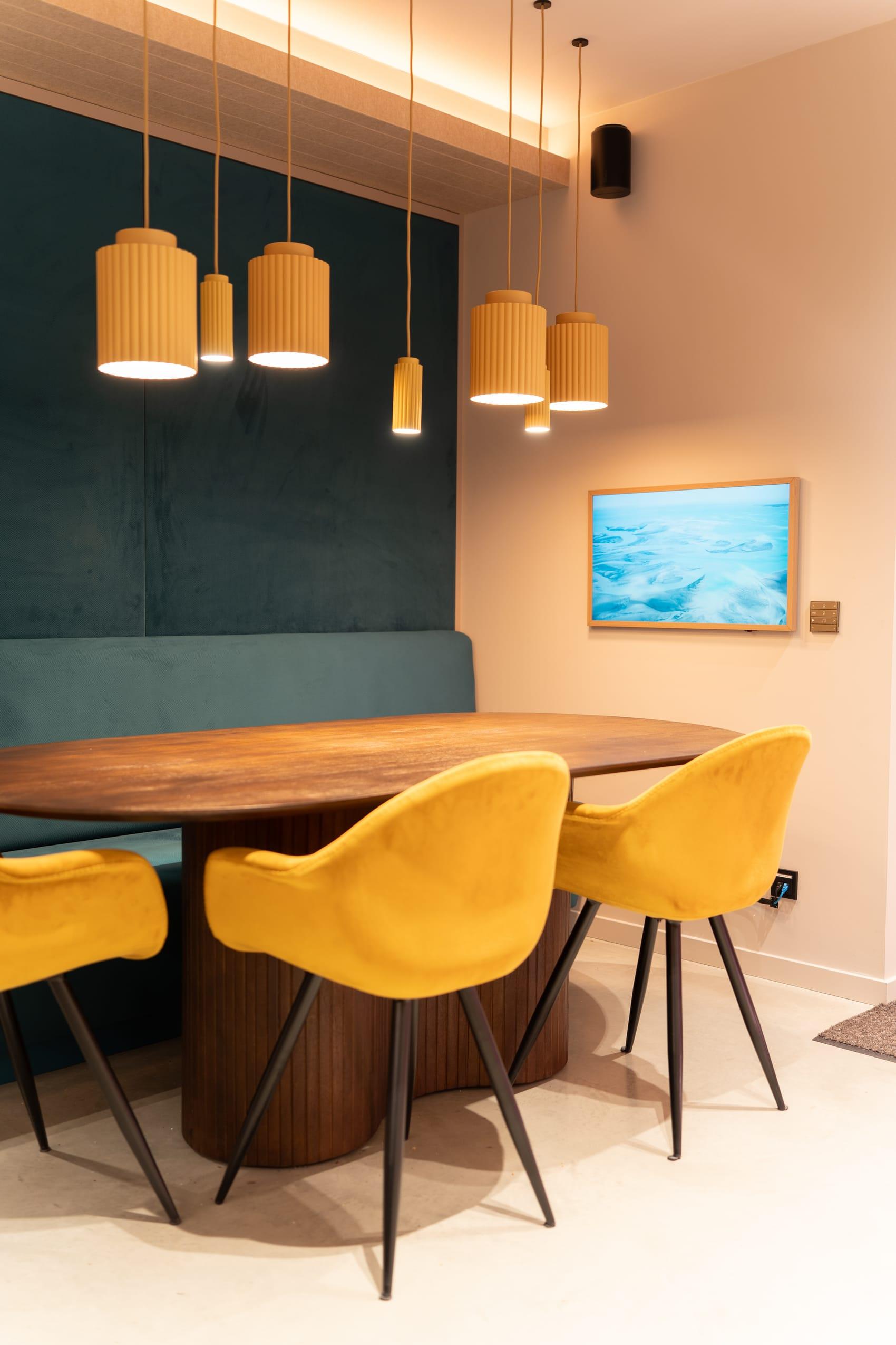 Zithoek met okergele stoelen en kunst